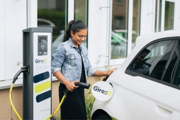 Frau lädt Elektroauto an Giro-e Ladezäule | nachhaltige Mobilitätslösungen und Bezahlsysteme der GLS Mobility
